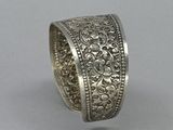 an antique silver ring with filigree design on a plain surface
