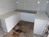 a dirty kitchen with a white refrigerator and white cabinets