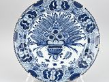 une assiette ancienne bleue et blanche ornée d'un motif de paon