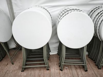 de nombreuses tables et chaises blanches dans une pièce ornée d'un rideau blanc