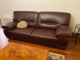a brown leather couch in a living room with a coffee table