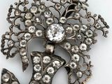an antique silver broochle with a bird and flowers on it
