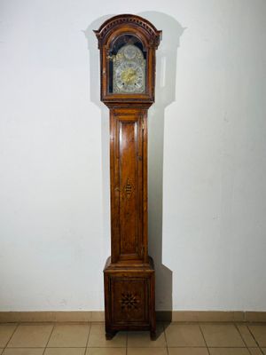 a tall wooden grandfather clock in the corner of a room