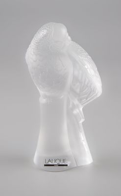 une figurine en verre transparent surmontée d'un oiseau