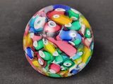 a colorful glass bead on a black surface