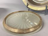 a glass plate with a gold rim and a silver plate with a gold rim on it