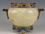 un vase blanc surmonté d'une couronne dorée
