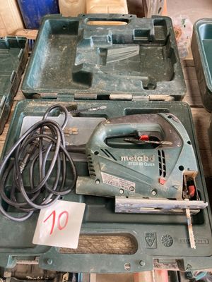 une boîte verte sur laquelle sont posés des outils, posée sur une table