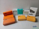 plusieurs boîtes de différentes couleurs et tailles contenant des appareils électroniques, posées sur une table