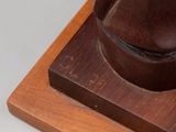 sculpture of a horse on a wooden base on a white surface