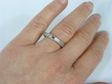 a woman ' s hand with a diamond ring on it