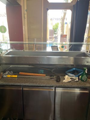stainless steel counter top with tools on it in front of a window