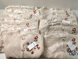four pairs of white sweaters with red flowers on them are wrapped in plastic