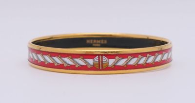 un gros plan d'un bracelet rouge et blanc posé sur une surface blanche