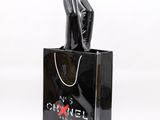 chanel black shopping bag with a woman ' s hand holding a chanel bag