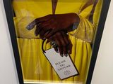 painting of a woman ' s hand holding a tag with a name tag attached to it