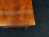 a small table with a wooden top on a black carpet