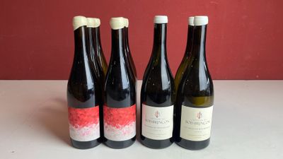 quatre bouteilles de vin sont alignées sur une table