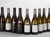six bottles of wine are lined up in a row on a white surface