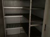 a small room with shelves and a door to another room