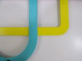 two yellow and blue hooks on a white wall