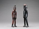 deux figurines en bois représentant un homme et une femme debout l'un à côté de l'autre