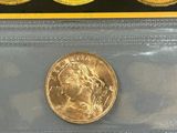 a close up of three gold coins in a plastic case