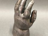 an image of a silver statue of a hand on a table