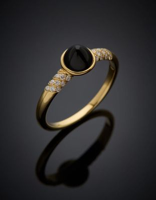 une bague en or sertie d'une pierre noire et de diamants