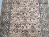 an antique persian rug with a floral design on a beige ground