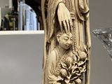 une statue représentant une femme tenant un enfant dans ses bras, posée sur une étagère