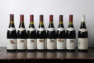 six bottles of wine are lined up on a wooden table