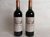 two bottles of red wine sitting next to each other on a white surface