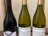 three bottles of wine sitting on a table next to each other