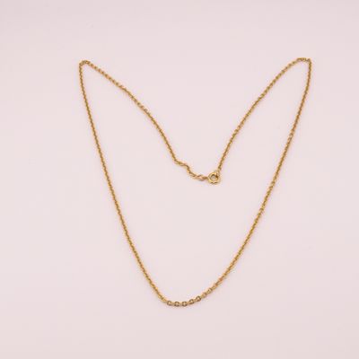 un collier à chaîne en or orné d'une boule sur fond blanc