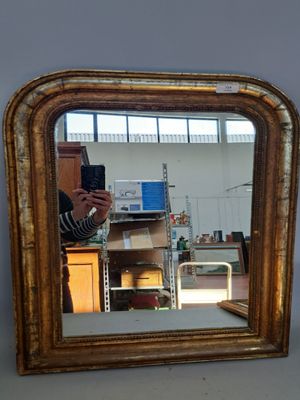 Miroir de forme cintrée en bois doré et frise de perles. (Pe…