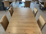 tables and chairs in a large room with a fireplace in the background