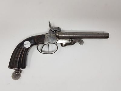un vieux revolver avec une poignée en bois sur une surface blanche