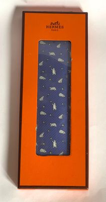 an orange box with a blue tie in it on a white surface
