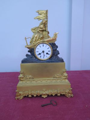 une horloge dorée posée sur une table rouge