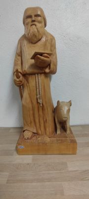 une statue représentant un homme tenant un livre et un chien