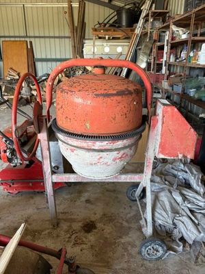 une bétonnière rangée dans un garage avec d'autres outils