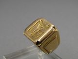 an image of a gold signet ring on a clear stand