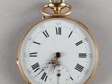 a gold pocket watch with roman numerals on the face