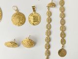 several different types of gold jewelry are displayed on a white surface