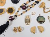 a lot of jewelry on a table with a cup of coffee