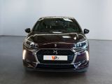 the front view of a dark colored car in a showroom