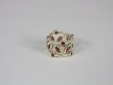 a silver ring with garnets on it on a white surface