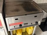 un plan de travail en acier inoxydable sur lequel sont posés deux bacs jaunes, dans une cuisine professionnelle