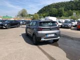 many cars parked in a parking lot with a mountain in the background